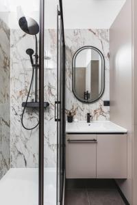 a bathroom with a sink and a mirror at Sir John's Apartments in Rijeka +24 photos