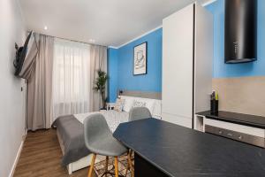 a small room with a bed and a table and chairs at Sir John's Apartments in Rijeka