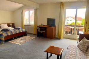a hotel room with a bed and a desk with a television at Gasthof zum Roten Löwen in Hildisrieden