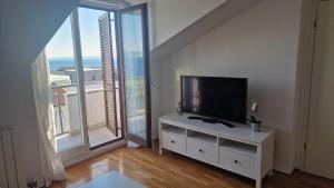 a living room with a flat screen tv on a white cabinet at Rooftop sea view apartment in Split