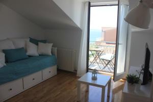a living room with a couch and a large window at Rooftop sea view apartment in Split