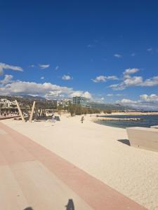 a beach with people walking on the sand and the water at Rooftop sea view apartment in Split