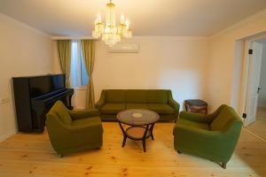 a living room with two green couches and a table at Seaside Escape In Poti in Poti