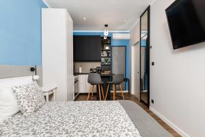 a bedroom with a king sized bed and a kitchen at Sir John's Apartments in Rijeka