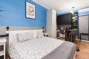 a bedroom with a bed and a blue wall at Sir John's Apartments in Rijeka