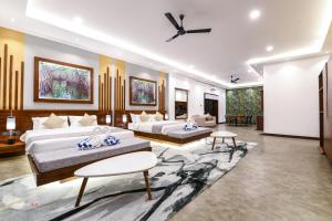 Un dormitorio con dos camas y una sala de estar. en Madu River Reach, en Balapitiya