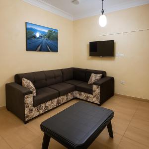 a living room with a couch and a flat screen tv at White Apartment in Aqaba