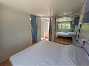 Un dormitorio con una gran cama blanca y un espejo. en La Vigne, en Lecci