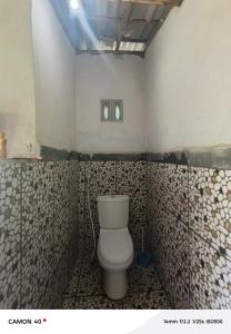 a bathroom with a toilet in a room with tiles at Bale bangket in Kotaraja