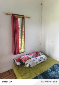 a bed in a room with a window at Bale bangket in Kotaraja