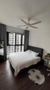a bedroom with a large bed with a ceiling fan at Geo Bukit Rimau Apartment in Shah Alam