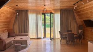 a living room with a couch and a table at Wood cottage in Borjomi in Borjomi