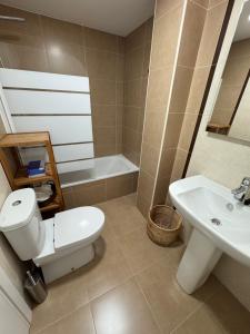 a bathroom with a toilet and a sink and a tub at Camino Fisterra Beach - Apartment in Fisterra +12 photos