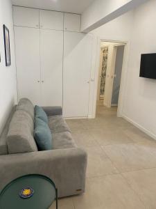un soggiorno con un divano e una televisione di Il Rosmarino a Napoli