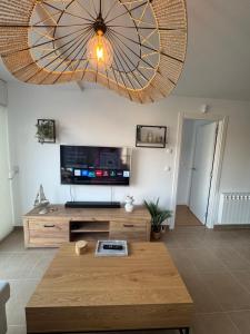 a living room with a large chandelier at Camino Fisterra Beach - Apartment in Fisterra