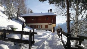 a building with a fence in the snow at Sunny and spacious apartment in chalet Faigaux in Veysonnaz situated in quiet area with magnificent mountain views in Veysonnaz