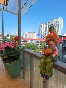 una bambola seduta sul davanzale di un balcone di Chase Dream Hostel追梦空间 a Batumi