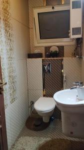 Un baño con inodoro y un televisor en la pared. en Luxurious panoramic Nile view room, en El Cairo
