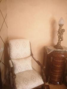 Una habitación con una silla y una lámpara al lado de una mesa. en Luxurious panoramic Nile view room, en El Cairo