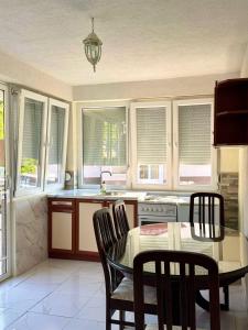 a kitchen with a table and chairs and windows at Apartments Slavica in Ohrid