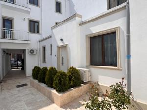 a white apartment building with a courtyard with bushes at AT Modern Boutique in Bucharest