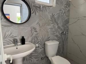 a bathroom with a sink and a mirror and a toilet at Angels Rooms in Ksamil +58 photos