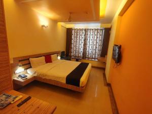 a bedroom with a bed and a television in it at Hotel Apex Intercontinental in Jaipur