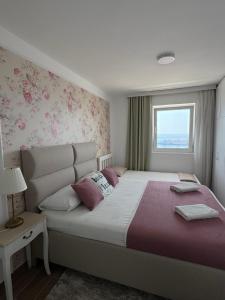 Un dormitorio con una cama grande y una ventana. en Pine&Sea Beach Retreat, en Sveti Stefan