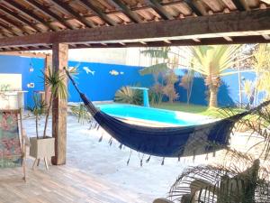 a hammock in a patio with a pool at CasaLegal in Búzios