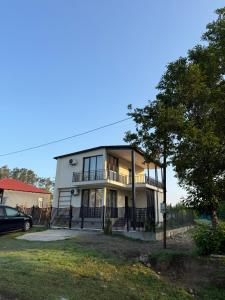 a white house with a fence in front of it at Vakho house - first floor in Urekis Sadguri