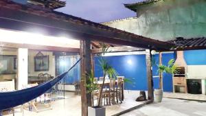 a hammock in a house with a blue wall at CasaLegal in Búzios