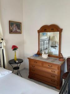 ein Schlafzimmer mit einer Kommode, auf der ein Spiegel steht in der Unterkunft Constantina in Skala Kallonis