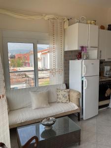 ein Wohnzimmer mit einem weißen Sofa und einem Kühlschrank in der Unterkunft Constantina in Skala Kallonis