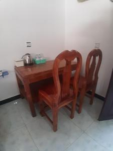 a wooden table with two chairs and a pot on it at Ban Sokluy AC apartment 3 1-2pax including kitchen in Siem Reap