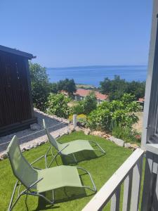 a balcony with two lawn chairs and the ocean at Mobile home Relax in Klenovica