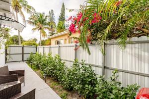 a fence with pink flowers on top of it at Miami North Beach in North Miami Beach