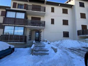 a building with a pile of snow in front of it at Charmant studio cabine mezzanine pour 4 personnes, proche centre, casier à skis - FR-1-295-130 in Les Angles