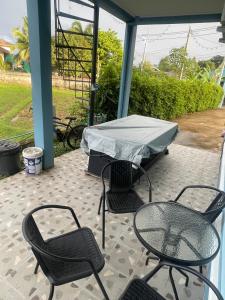 Un patio con sillas y una mesa con una sábana encima. en บ้านกลางนาพูลวิลล่า, en Nan