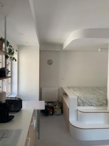 a white kitchen with a bed in a room at Studio Dizy in Villers-sur-Mer