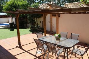 a table and chairs on a patio with a pergola at El Rincón de Orión in Ciudad Real