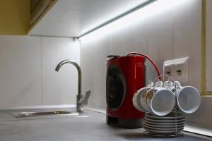 a red coffee pot on a kitchen counter with cups at El Rincón de Orión in Ciudad Real +14 photos