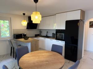 a kitchen with a table and a black refrigerator at Apartman Meld in Vrh