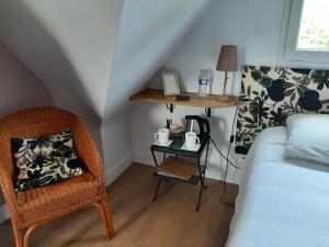 a bedroom with a bed and a table and a chair at Chambres d'hôtes de Ty Guen in Trédarzec