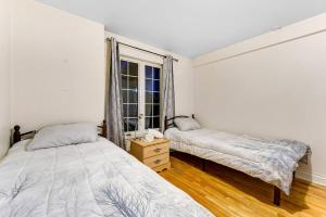 a bedroom with two beds and a window at Cozy Chalet Val Morin in Val-Morin