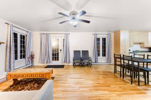 a living room with a ceiling fan and a table at Cozy Chalet Val Morin in Val-Morin