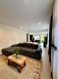un soggiorno con un divano e un tavolo di Maison spacieuse avec terrasse - DABNB a Saint-Brice-sur-Vienne