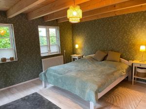 a bedroom with a bed and two windows at Ferienhaus Emma in Langelsheim
