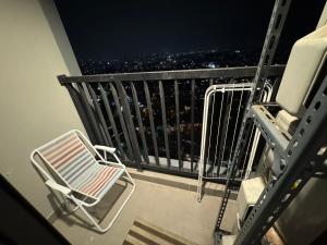 a balcony with a chair and a city at night at Apartemen Embarcadero in Pondokpucung