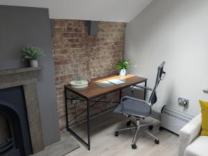 a desk in a room with a brick wall at Digital Nomad Studio in Norwich