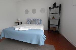 a bedroom with a white bed with two pillows on it at Freedom Surf House in Serra de El-Rei